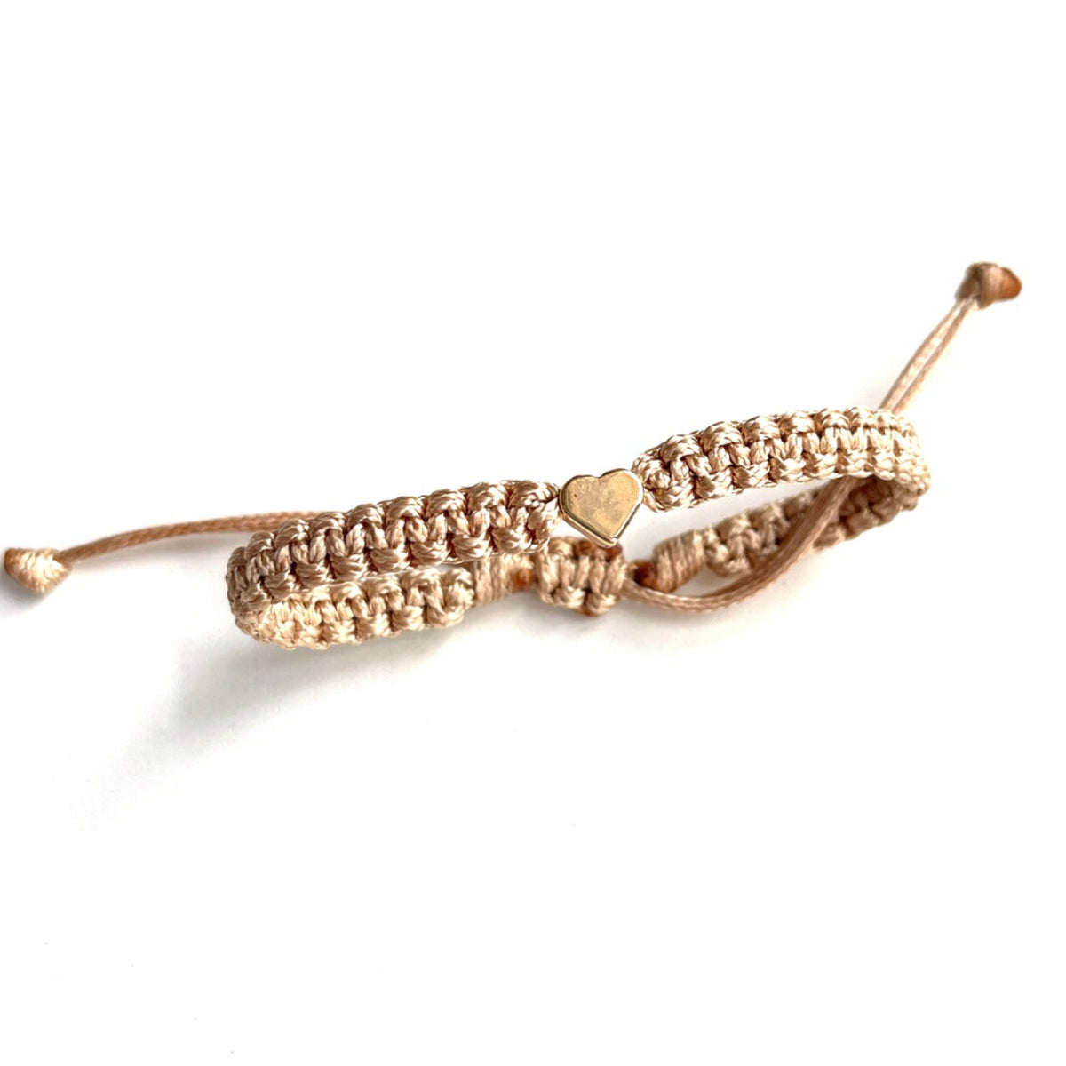 Gold bracelet with a heart charm on a white background