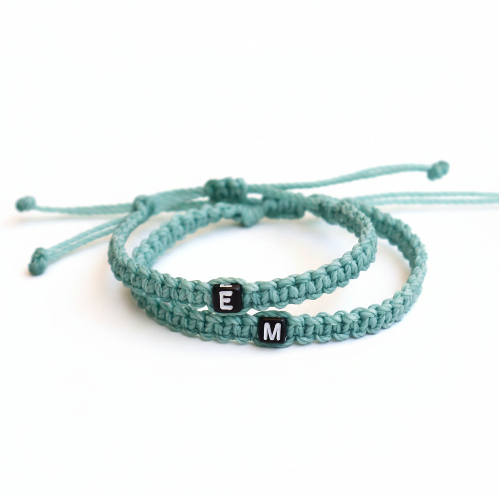 Mommy and me matching bracelet set, mint green macrame cord with custom letter beads, personalized initial jewelry, adjustable slide-knot closure on rustic wood background