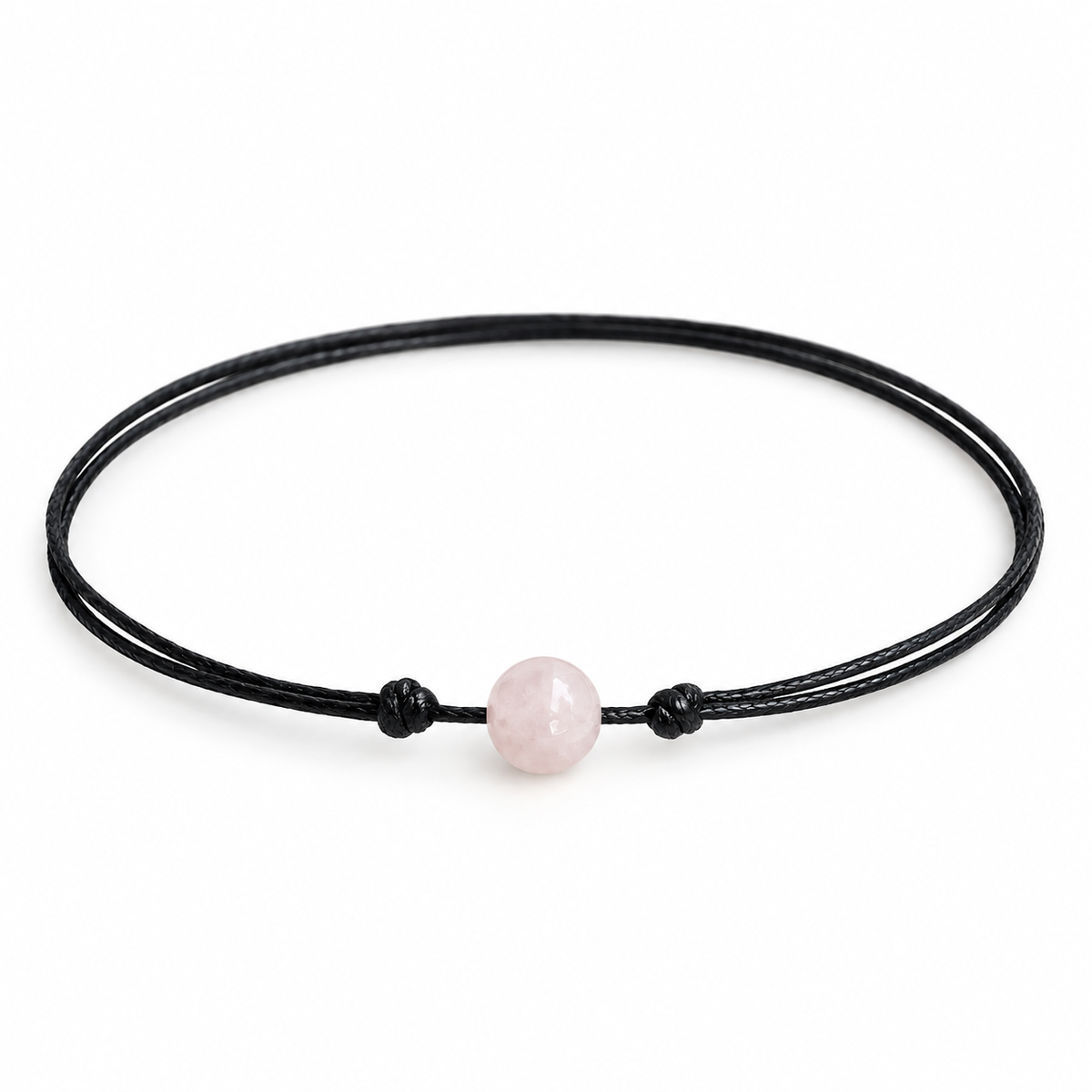 Rose quartz stone bead choker on black waxed cord with adjustable slide-knot closure, laid on a rustic wooden background.