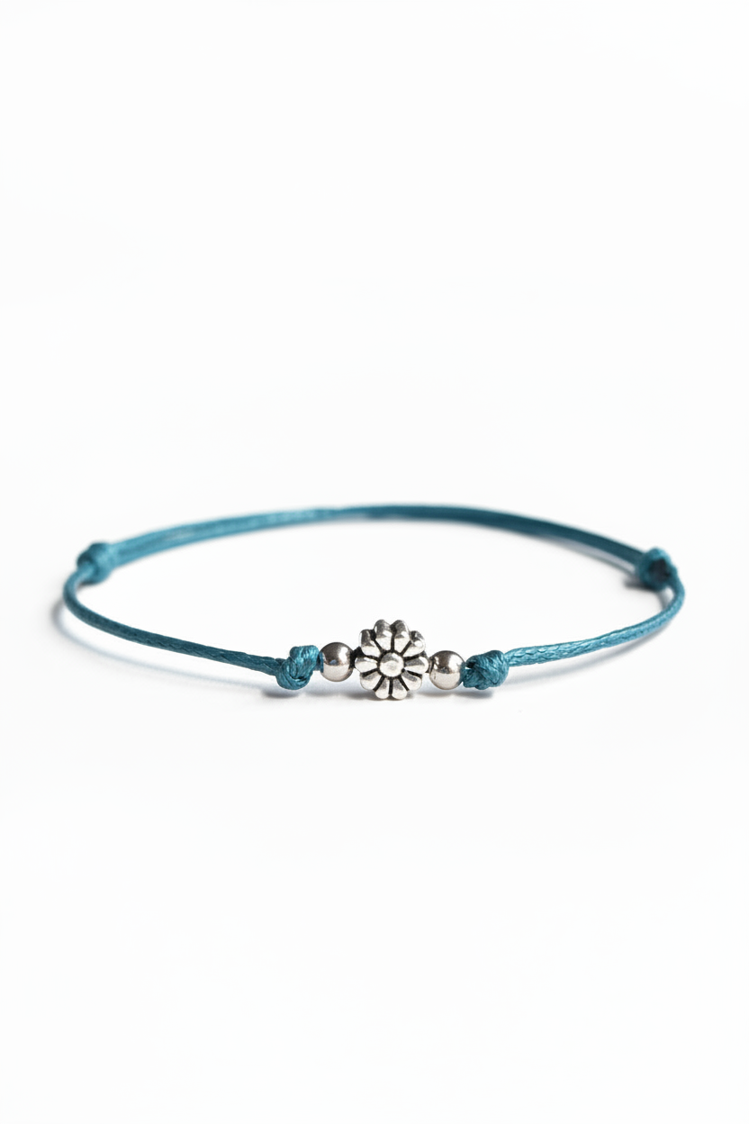 Teal bracelet with a silver flower charm on a white background
