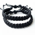 Two black braided bracelets stacked on a white background 
