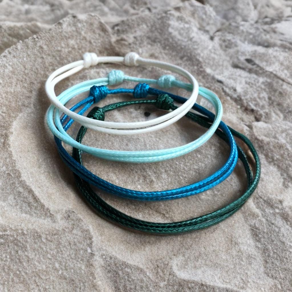 White, Sky Blue, Turquoise, Deep Teal. Collins 2mm Minimalist bracelets in shades of green, blue, and white.