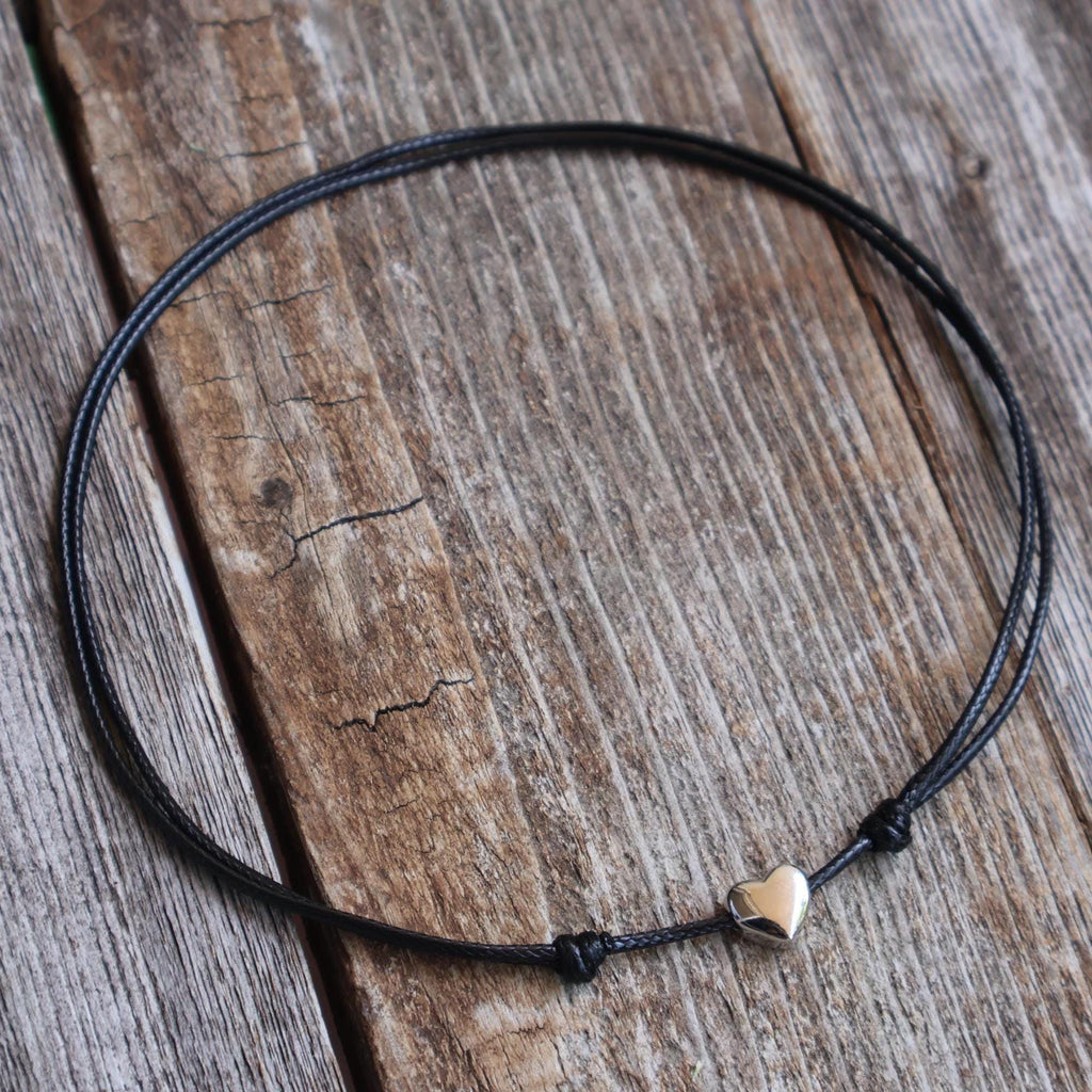 Sterling silver heart choker displayed on rustic wood background
