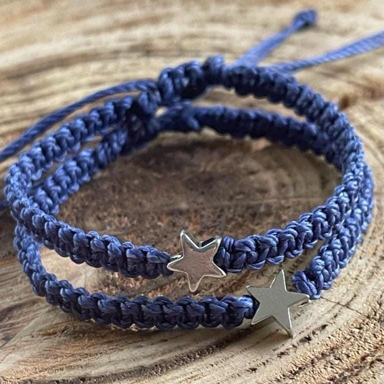 Two silver star charms navy blue macrame bracelets. The bracelets are knotted and have adjustable ties.