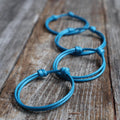 Four blue cord family matching bracelets. The bracelets are made of a 2mm blue cord and have a simple knot design.