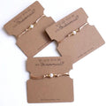 Would You Be My Bridesmaid freshwater pearl bracelets with gold plated beads on kraft cards, set of three displayed on white background