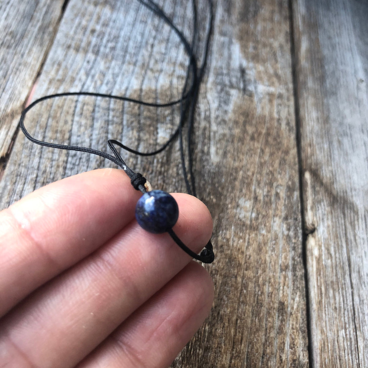 Lapis lazuli blue bead black cord choker necklace flat lay adjustable