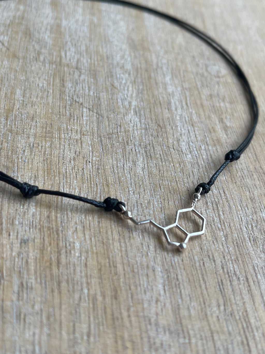 Serotonin molecule black cord choker necklace flat lay adjustable closeup